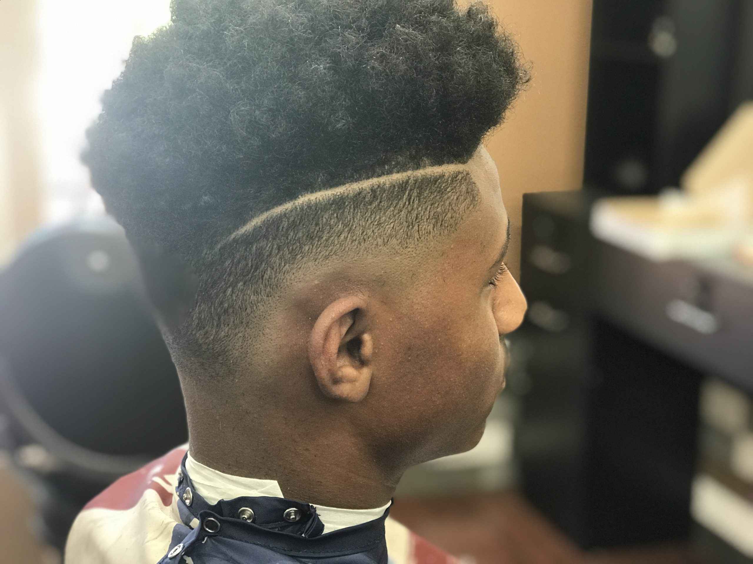 Side profile of a high-top fade with a razor hard part