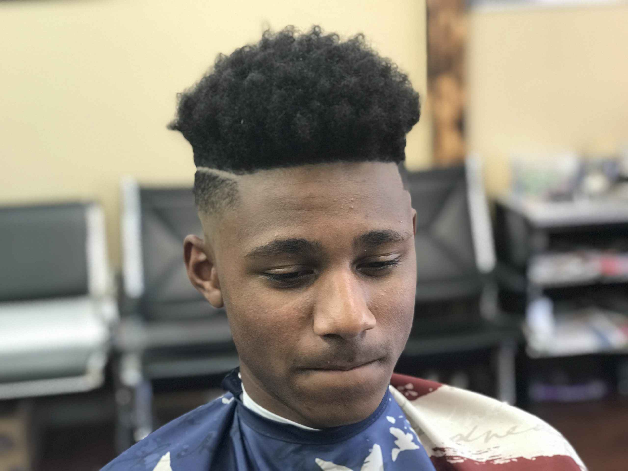 Front view of a finished high-top fade with a part, in the chair