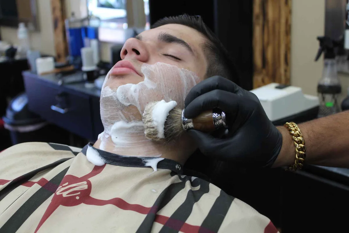 Lather being brushed onto a client’s face