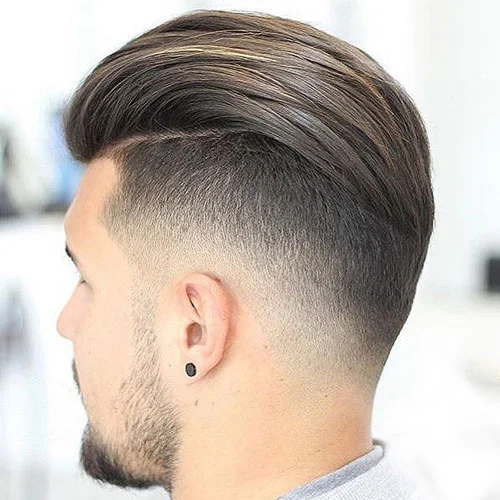 Skin fade with the top swept back and a lined-up beard, side profile